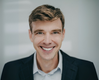 Man in a suit smiling to the camera